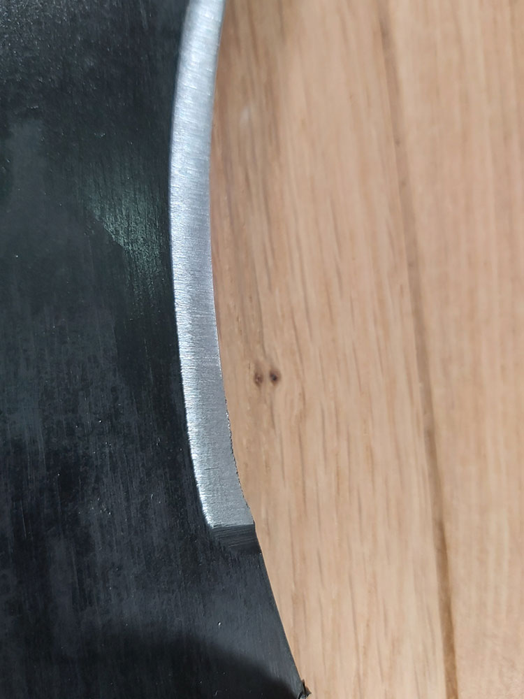 Close up of a brand new, unused Cold Steel machete with a few small burrs on the edge
